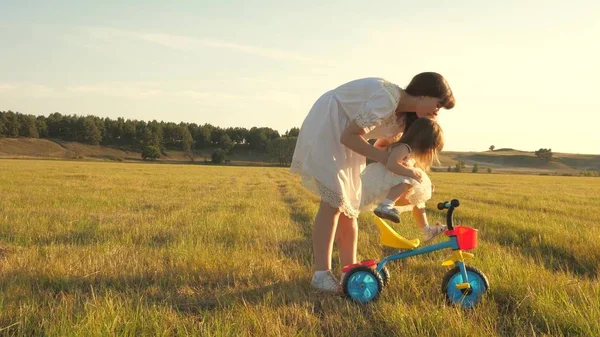 Mama uczy córkę jeździć na rowerze. Matka gra z jej małą córką. małe dziecko uczy się jeździć na rowerze. koncepcja szczęśliwego dzieciństwa. — Zdjęcie stockowe