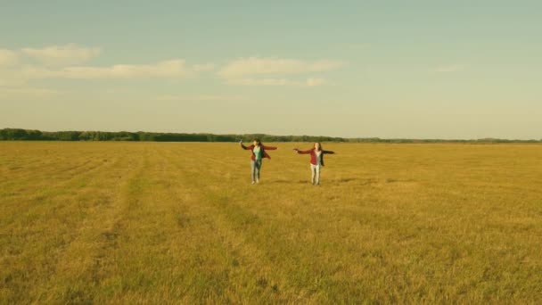 Kinderen spelen speelgoed vliegtuig. tieners willen piloot en astronaut worden. Happy Girls lopen met speelgoed vliegtuig bij zonsondergang op veld. concept van Happy Childhood. Meisjes dromen van het vliegen en een piloot worden — Stockvideo