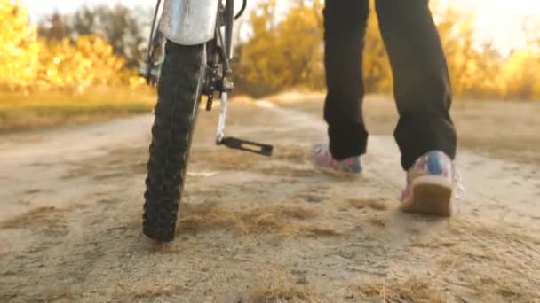 Ett cykelhjul rullar längs vägen. Närbild. Slow motion. barn reser med cykel. tonåringen går på vägen med en cykel. flickan går in för sport på en cykel. — Stockvideo