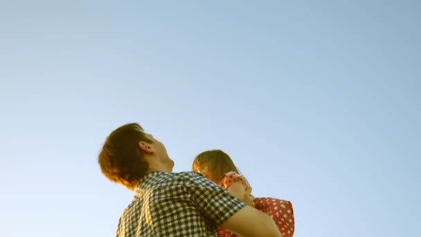 Begreppet lycklig familj. Pappa kastar baby upp högt mot himlen. Pappa leker med sin lilla dotter i parken. Pappa kastade baby i blå himmel. — Stockvideo