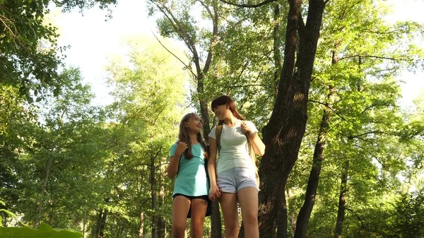 Teamwork Touristen Teenager. Glückliche Mädchen gehen mit Rucksäcken in den Wald. Wanderin geht im Wald spazieren. glückliche Wanderin im Sommerpark. Teenager Mädchen Abenteuer im Urlaub. — Stockfoto