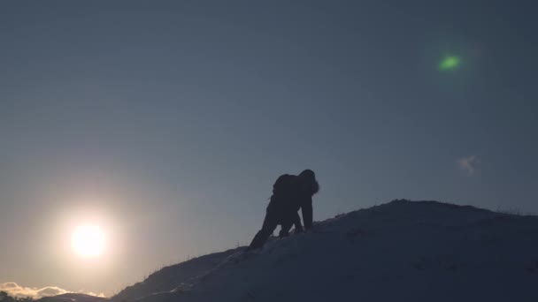 El escalador desciende lentamente de la montaña nevada para no caer. Caminatas extremas turísticas en montañas. Caminante viajero. Conquista de picos por el hombre — Vídeos de Stock