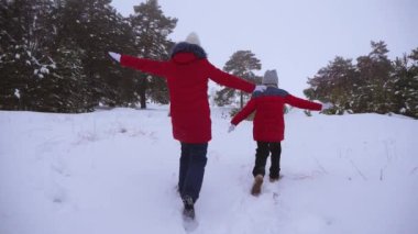 Noel tatili için kız kardeşler ve arkadaşlar kışın parkta koşup oynarlar. Mutlu çocuklar kışın karlı ormanda süper kahramancılık oynuyor..