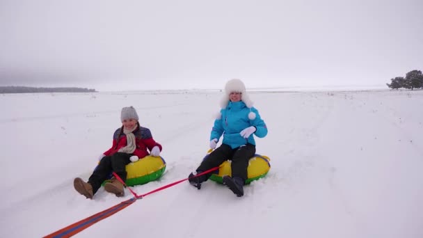Rodinné hraní v zimním parku během vánočních prázdnin. Šťastná maminka děti bruslí v zimě ve sněhu a hrát sněhové koule. Máma a dcera se smějí a radují. Zpomal. šťastný rodinný koncept. — Stock video