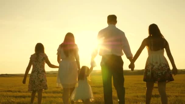Μητέρα, πατέρας και μικρή κόρη με αδερφές να περπατούν στον ήλιο. Ευτυχισμένη οικογένεια. Παιδιά, ο μπαμπάς και η μαμά παίζουν στο λιβάδι στον ήλιο. έννοια της ευτυχισμένης οικογένειας. — Αρχείο Βίντεο