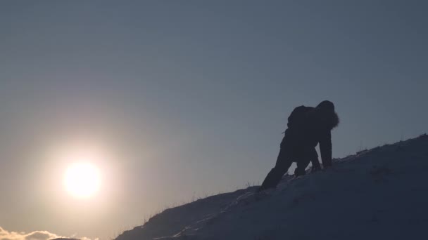 男性登山者は、順番に落ちる雪の山からゆっくりと下って行きます。山で極端なハイキング観光。旅行をハイキングします。人によってピークの征服 — ストック動画