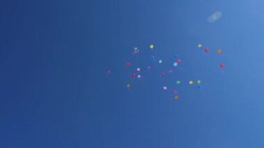 Güzel renkli balonlar gökyüzünde uçuyor, kırmızı mavi turuncu pembe. Havada uçuşan bir sürü renkli balon. Kutlama ve doğum günü konsepti. Güzel bir tatil konsepti.