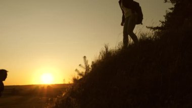 Gezgin kadın, bir adamın elini bir gezginin tepeye tırmanmasına uzatır. Turistler gün batımında el ele tutuşarak dağa tırmanırlar. İş adamlarından oluşan takım çalışması. Mutlu aile tatilde..