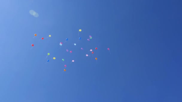 Mooie gekleurde ballonnen vliegen in de lucht, rood blauw geel oranje roze. Veel kleurrijke ballonnen vliegen in de lucht. Feest- en verjaardagsconcept. Het concept van een mooie vakantie. — Stockvideo