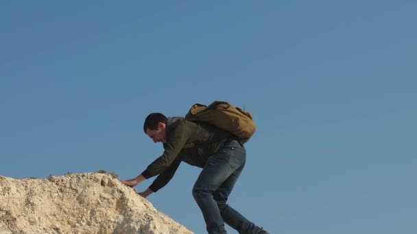 Os escaladores escalam um após o outro na rocha branca. turistas dão a mão uns aos outros, subindo para o topo da colina. trabalho de equipa de pessoas de negócios. equipe de viajantes do sexo masculino vai para a vitória e sucesso . — Vídeo de Stock