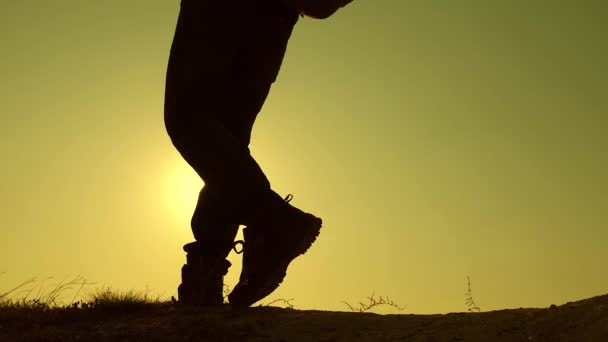 Reizigers met rugzakken dalen één voor één de heuvel af. Teamwork mannen voor overwinning en succes. toeristen met rugzakken lopen over het veld in felle stralen van de zon. Langzame beweging — Stockvideo