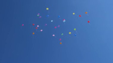 Gökyüzünde kırmızı mavi turuncu pembe renkli balonlar uçuyor. Havada uçuşan bir sürü renkli balon. Kutlama ve doğum günü konsepti. Güzel bir tatil konsepti.