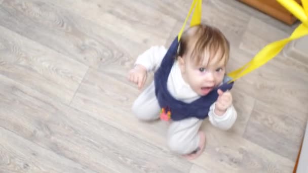 Fröhliche kleine Baby springt in Kinderpullover und saugt die Faust. Lernspiel für Kinder. glückliche Kindheit zu Hause — Stockvideo