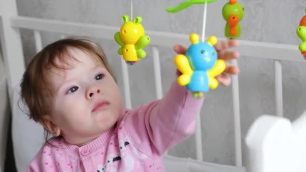 Baby is playing toys in his crib, in children room. — Stock Video