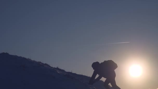 Bergsteiger steigt langsam vom schneebedeckten Berg herab, um nicht zu stürzen. Extremwanderungen Touristen in den Bergen. Wanderreisende. Die Eroberung der Gipfel durch den Menschen — Stockvideo