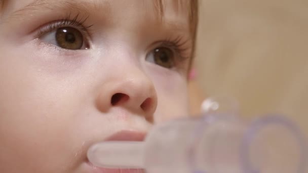 Hastanede yüzünde solunum maskesiyle tedavi edilen küçük bir kız. Çocuk hasta ve astım spreyinden nefes alıyor. Yürümeye başlayan çocuk, solunum buharı soluyarak grip tedavisi görüyor.. — Stok video