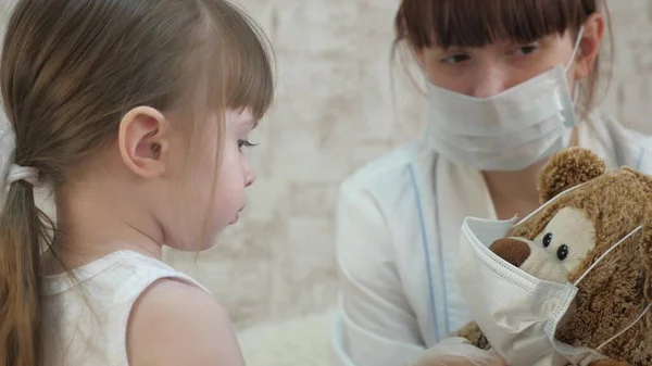 Un niño pequeño trata a los animales de juguete con inyecciones. La niña juega con mamá en el hospital. Juego de médico, enfermera, tratar con la vacuna. niña sana y oso de juguete. niño juega en el hospital . — Foto de Stock