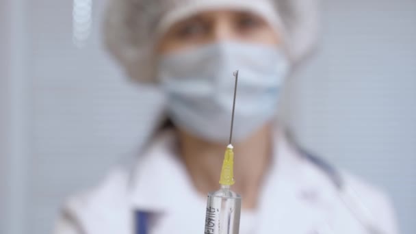 Verpleegkundige houdt een spuit met geneesmiddel in zijn hand. de arts een injectiebehandeling heeft voorgeschreven. De arts is klaar om de patiënt een injectie te geven. vaccin tegen ziekte in de hand van de arts. — Stockvideo