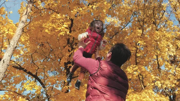 Papá vomita una hija feliz en el cielo en otoño en el parque. familia feliz viaja. Padre e hijo juegan, ríen y abrazan. niño sano en brazos de los padres. Papá está fuera. Concepto de familia feliz — Foto de Stock