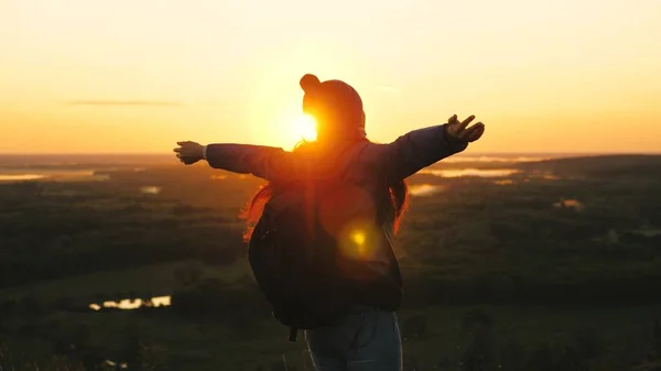 Свободненская девушка-туристка на природе одна. молодая женщина путешественник с рюкзаком приходит к краю пика восхода солнца, поднимает руки в воздухе и вращается, наслаждается победой, красивый рассвет и пейзаж . — стоковое фото