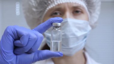Doktor enjeksiyon tedavisi önerdi. Bir hemşire elinde ilaçla bir ampul tutuyor. Hastalık aşısı doktor elinde. Covid 19. Doktor hastaya iğne yapmaya hazır..