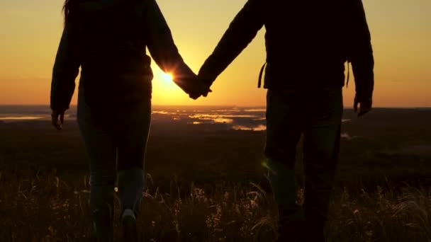 Reizigers, een man en vrouw met rugzak, gaan naar de rand van de heuvel in de stralen van de dageraad, heffen hun handen, klappen in hun handen en genieten van de overwinning en prachtige zon en landschap. familie reizen en toerisme concept — Stockvideo