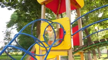 Çocuk ve anne oyun parkında oynuyorlar. Çocuk kaydırağındaki çocuk. Mutlu bir çocukluk ve aile kavramı. Küçük çocuk parktaki oyun alanının tadını çıkarıyor. Çocuk annesiyle dışarıda oynuyor.