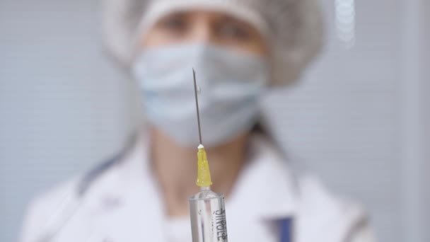과학자들은 주사기를 손에 쥐고 있습니다. 의사는 주사 치료법을 처방하였다. 의사는 환자에게 주사를 놓을 준비가 되어 있다. 의사의 손에 있는 질병 백신. — 비디오