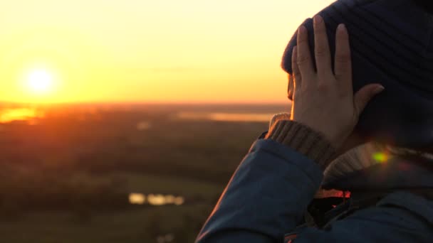 Giovane viaggiatrice con uno zaino arriva sul bordo di una montagna picco del sole, alza le mani in aria e gode di vittoria, bel sole e paesaggio. ragazza libera turista viaggia nella natura — Video Stock