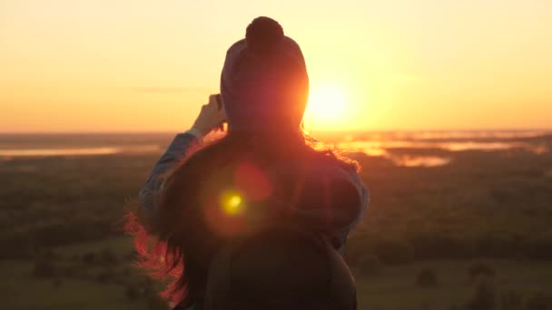 La donna allegra sana viaggia all'alba e fotografa la natura a telefono. gratis Giovane turista blogger registra un selfie video in cima alle montagne utilizzando uno smartphone con un bellissimo paesaggio. — Video Stock