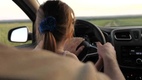 Pappa lär sin dotter att vrida ratten medan han sitter i sin bil i förarsätet. far reser med barn med bil. Chauffören och ungen kör. lycklig familj och barndom koncept — Stockvideo