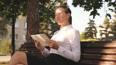 Bayan öğrenci sokakta ders veriyor. Bankta bir tabletle. Elinde tabletle genç bir kızın portresi. Güzel, özgür bir kadın iyi haberler okuyor. Sokakta elinde aletle genç bir öğrenci