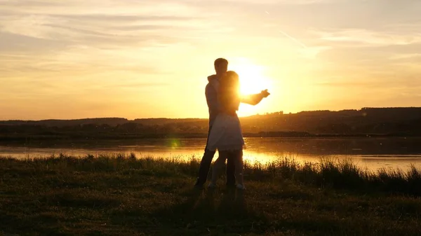 Jeune couple gratuit dansant au coucher du soleil sur la plage. Happy guy and girl valse en soirée dans un parc d'été. Homme et femme amoureux dansent dans les rayons lumineux du soleil sur le fond du lac. — Photo