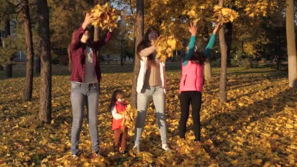 Tato, mama i córki wymiotują żółtymi liśćmi. zdrowe dzieci i rodzice bawiący się na świeżym powietrzu. szczęśliwa rodzina bawiąca się w jesiennym parku. zdrowa szczęśliwa rodzina i koncepcja dzieciństwa. Zwolniony ruch — Wideo stockowe