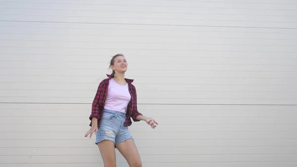 Dança divertida de um adolescente na moda. Menina saudável feliz dançando ao ar livre em uma rua da cidade, se divertindo, rindo. O conceito de estilo de vida moderno, amizade e felicidade. festa, flash mob. — Fotografia de Stock