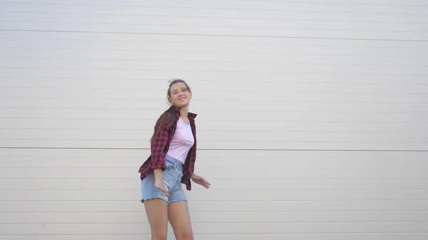 Dança divertida de um adolescente na moda. Menina saudável feliz dançando ao ar livre em uma rua da cidade, se divertindo, rindo. O conceito de estilo de vida moderno, amizade e felicidade. festa, flash mob. — Fotografia de Stock