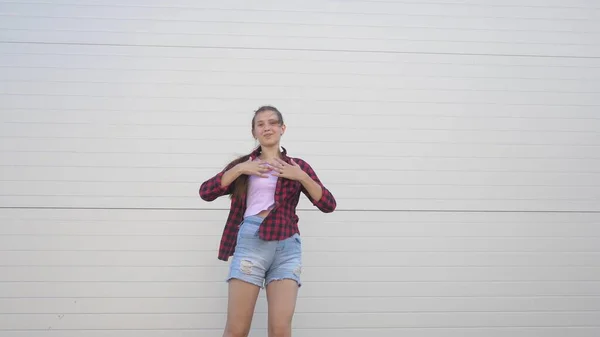 Fun dance of a trendy teenager. Happy healthy girl dancing outdoors on a city street, having fun, laughing. The concept of modern lifestyle, friendship and happiness. party, flash mob. — Stock Photo, Image