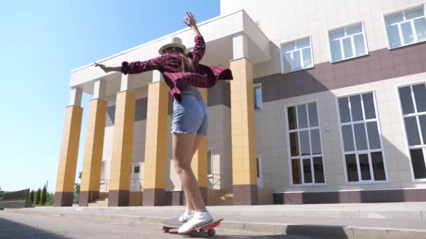 Gesunder und aktiver Lebensstil des modernen Teenagers. schöne Mädchen lernt Skateboard im Freien unter der Sonne. Glückliche Skateboarder unterwegs in der Stadt. — Stockvideo
