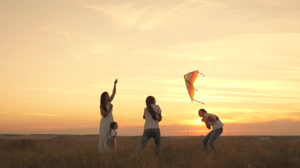 Moeder en geliefde dochters lanceren kleurrijke papieren vliegtuigen de lucht in. moeder met kinderen spelen met vliegers bij zonsondergang in het park. gezond gezin buiten. leuk om te spelen met ouders in de zon — Stockvideo