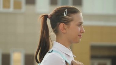 Eğitim konsepti. Genç bir kız aceleyle sınıfa gidiyor. Sırt çantalı bir liseli kız okula gidiyor. Güzel bir genç öğrenci sınıfa gidiyor..