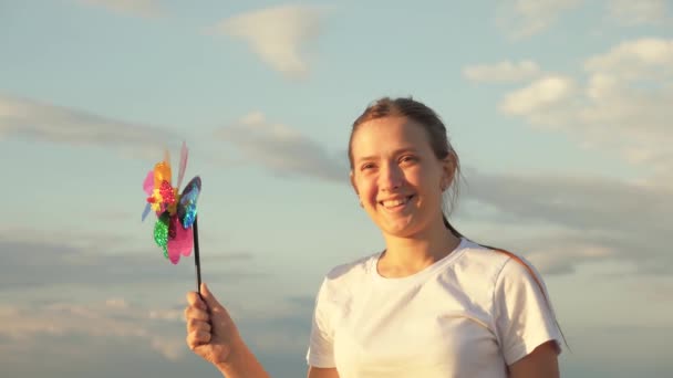 Happy child playing having fun pinwheel. Happiness vacation childhood happy family holiday. teen girl playing pinwheel park in slow motion. childhood concept. a child playing in park catches wind — Stock Video