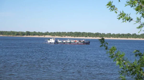 Small ship tanker moves on calm water through the sea strait. a small ship is sailing along the river. View from the shore of a river vessel, a cargo ship goes to the port. — Stock Photo, Image