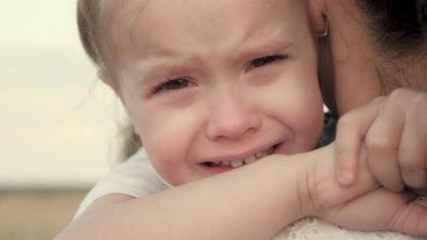 Maman apaise bébé. mère de famille et enfant avec des larmes dans les yeux étreint leur mère, émotionnellement. aimant jeune mère étreint et apaise sa petite fille, bébé pleure dans les bras par maman — Video