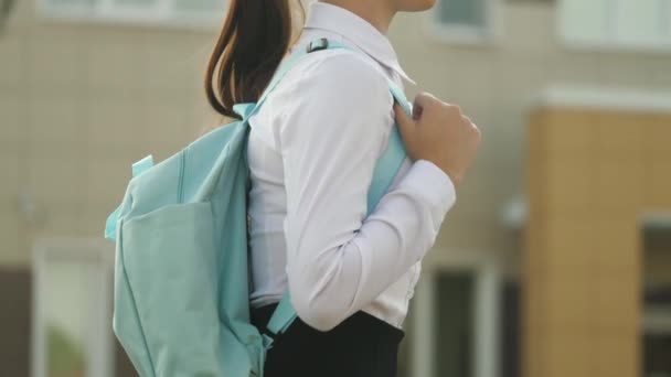 Konzept der Bildung. Ein Mädchen im Teenageralter eilt zum Unterricht. ein Schulmädchen mit einem Rucksack geht die Straße hinunter zur Schule eine schöne junge Studentin geht in die Klasse. — Stockvideo