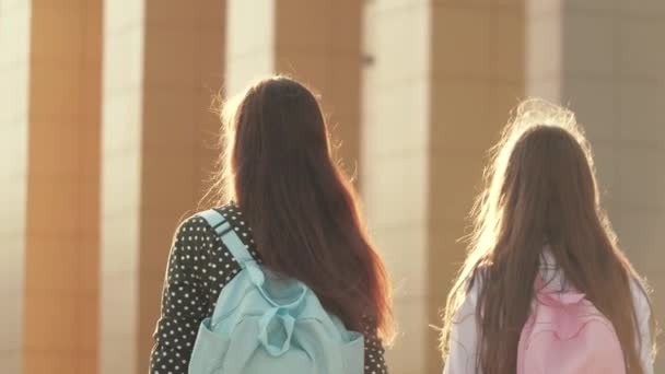 Mamma e figlia studentessa andare con uno zaino e tenere la mano delle madri. concetto di istruzione scolastica. felice famiglia madre e figlio andare a scuola tenendosi per mano. — Video Stock