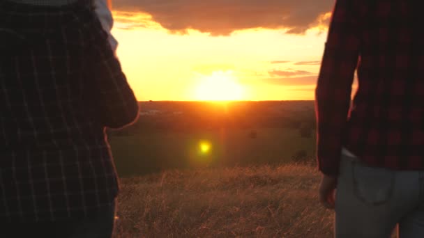 Feliz familia sana viaja. mamá papá y los niños caminan en la cima de la colina al atardecer y alegremente levantan sus manos y se regocijan. concepto de familia, infancia, libertad y viajes. padres e hijas — Vídeos de Stock