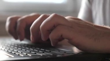 Eller klavyede. İş adamı, girişimci evde dizüstü bilgisayarla çalışıyor. Yakın plan. Bilgisayarın yardımıyla profesyonel bir erkek, iyi çalışıyor. Serbest İşçi, modern dizüstü bilgisayarla çalışıyor..