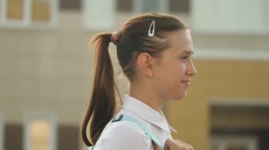 Eğitim konsepti. Genç bir kız aceleyle sınıfa gidiyor. Sırt çantalı bir liseli kız okula gidiyor. Güzel bir genç öğrenci sınıfa gidiyor..