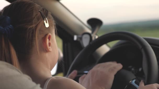 Pappa lär sin dotter att vrida ratten medan han sitter i sin bil i förarsätet. far reser med barn med bil. Chauffören och ungen kör. lycklig familj och barndom koncept — Stockvideo