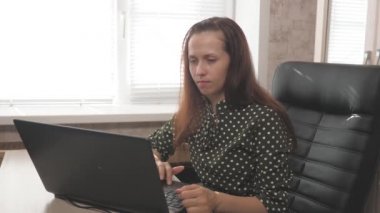 Modern taşınabilir bir cihazla çalışan serbest çalışan bir işçi. Modern iş kadını, evde dizüstü bilgisayarla çalışan girişimci. Ev ofisinden bilgisayar kullanan genç profesyonel bir kadın..